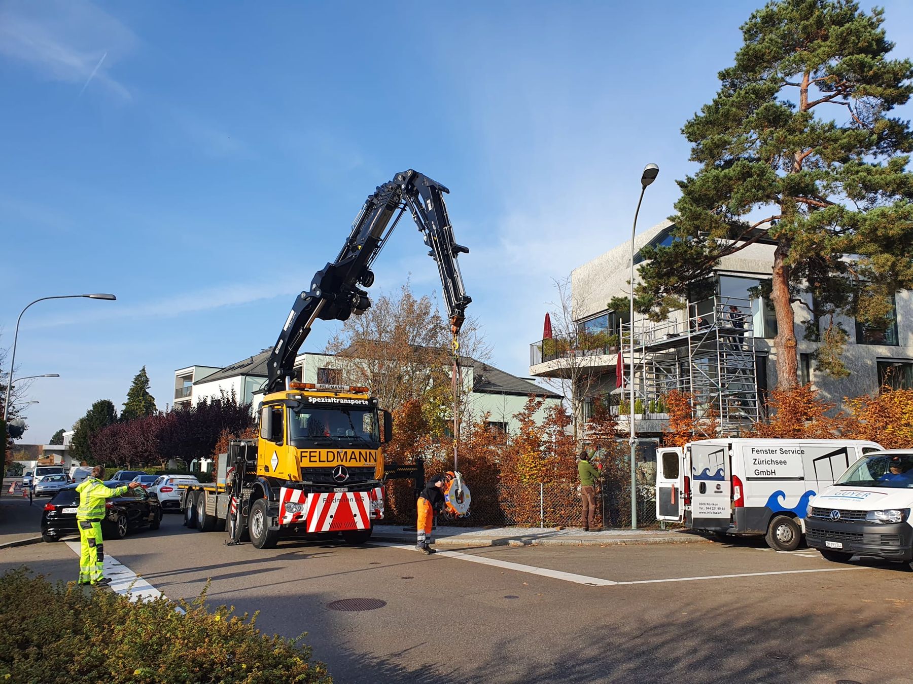 Lastwagenkran und Servicewagen bei einem Einsatz an einem Wohnhaus